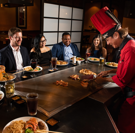Kobe chef preparing food while group of people watch hibachi clearwater