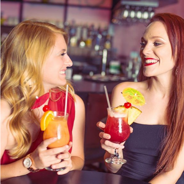 Two young women enjoying cocktails at Kobe